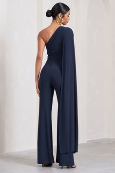 Every bit as elegant as it's name suggests, our navy Aurora jumpsuit is presented in sculpting stretch jersey with a sweeping cape sleeve that drapes from an asymmetric neckline. This wide-leg jumpsuit is not only versatile but made to flatter your unique figure whether you're headed to a bottomless brunch or an grand evening event this season. Features - Premium stretch jersey - Asymmetric neckline - Single cape sleeve - Invisible zip closure - Wide legs Sizing & Fit Model is 5’9" and wears UK size 8 / US size 4 Product Information Designed exclusively by Club L London Double layered with excellent stretch Premium jersey in Navy (95% Polyester, 5% Elastane) 85cm inside leg length SKU: CL126743 One Shoulder Cape, Shoulder Cape, Bottomless Brunch, Black Dress Prom, Black Tie Gala, Asymmetric Neckline, Party Dress Long Sleeve, Cape Sleeves, Bridesmaid Outfit