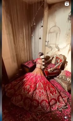 a woman in a red dress laying on top of a bed covered in pink flowers