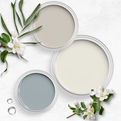 three different shades of paint next to each other on a white surface with flowers and leaves