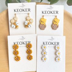 four pairs of earrings with winnie the pooh and daisy flowers hanging from each earring