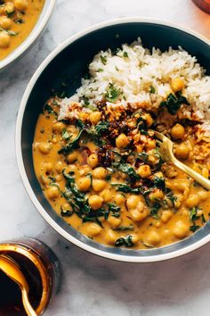 a bowl filled with rice and chickpeas on top of a table next to other bowls