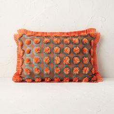 an orange decorative pillow on a white surface