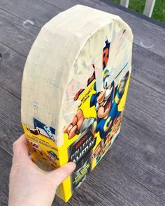 a hand is holding up a box with an image of the batman character on it