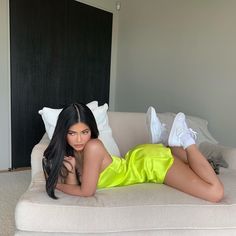 a beautiful woman laying on top of a white couch