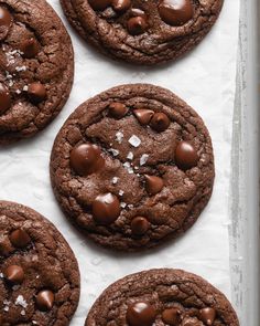 chocolate cookies with sea salt on top are lined up in a baking pan and ready to be eaten