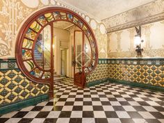 an ornately decorated hallway with a circular mirror in the center and checkered floor