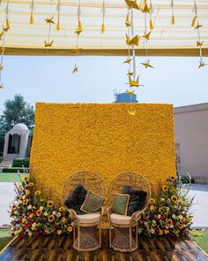 two wicker chairs sitting on top of a wooden table covered in flowers and birds