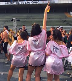 three women in pink robes are dancing on the sidelines