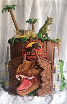 a cake with dinosaurs on top of it and the words dinosaur world written in large letters