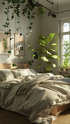 an unmade bed with plants hanging from the ceiling