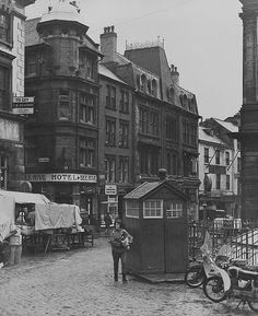 an old black and white photo of people in the street