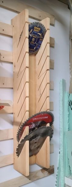 a pair of circular saws are mounted to a wooden rack on a white wall