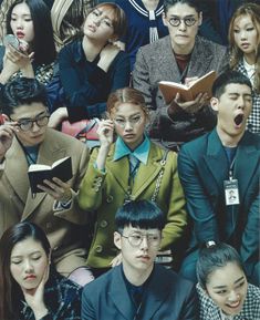 a group of people sitting next to each other in front of a crowd holding books