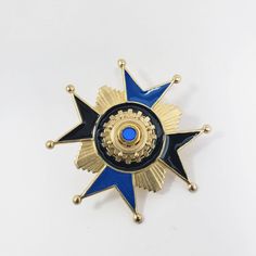 "Hand enameled brass Maltese Cross has beautiful vintage cabochon in center.  100% hand assembled by Spectra Nova Measures: 2.25\" x 2.25\" or 54mm x 54mm" Gold Cameo Medallion Brooches, Art Deco Comet Broach, Vintage Blue Enamel Pin Gift, Maltese Cross Jewelry, Collectible Blue Enamel Pin, Luxury Elegant Star-shaped Brooches, Antique Blue Enamel Brooches, Blue Enamel Collectible Pin, Red Patch