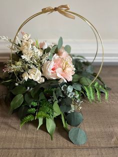 a basket filled with flowers and greenery on top of a wooden table