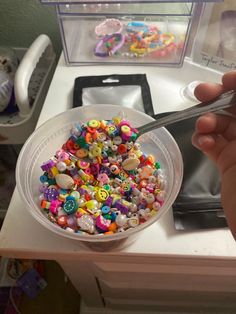 a person is holding a spoon over a bowl of cereal with letters and numbers on it