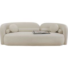 a white couch sitting on top of a floor next to a book case and pillow