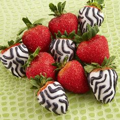 chocolate covered strawberries are arranged in a pyramid on a green tablecloth with polka dots