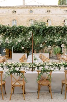 an outdoor table set up with flowers and greenery for a wedding reception in italy