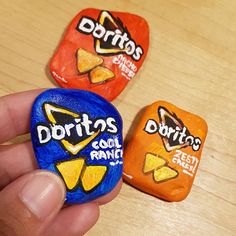 three different flavors of doritos are being held by a person's hand