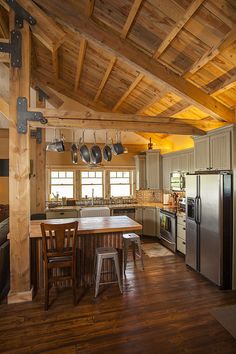 a kitchen with wood floors and wooden ceiling