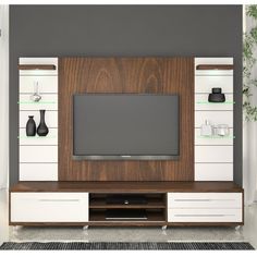 an entertainment center with a flat screen tv mounted on it's side, in front of a gray wall