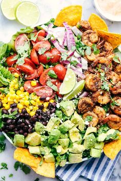 a salad with shrimp, avocado, tomatoes, corn and cilantro