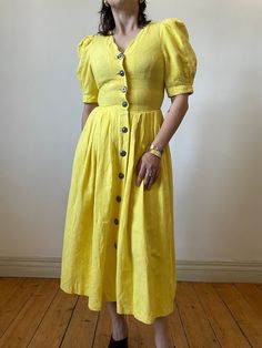 Gorgeous vintage trachten folk dress in beautiful bright yellow. Made out of cotton and linen blend. Fitted silhouette with accentuated waist and exaggerated puff sleeves.  - marked size: 34 - best fits size S  - 55% linen 45% cotton - great vintage condition MEASUREMENTS *taken seam to seam. not doubled, taken flat Shoulders: 31 cm | 12.2" Bust: 42 cm | 16.5" Waist: 34 cm | 13.3" Sleeve length:  32 cm | 12.9" Length: 112 cm | 44" For reference, our model is size S and is 5"2 tall  SHIPPING Sent Yellow Fitted Linen Dress, Fitted Yellow Linen Dress, Vintage Yellow Puff Sleeve Dress, Dress Puff Sleeve, Folk Dress, Dirndl Dress, Folk Dresses, Puff Sleeve Dress, Dress Yellow