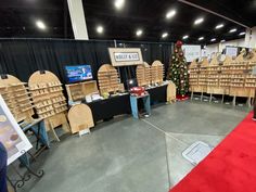 a room filled with lots of wooden shelves next to a red carpet and christmas tree