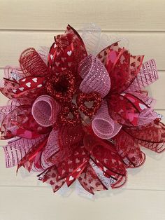 a close up of a red and white mesh wreath with hearts on the front door