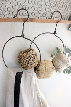 two balls of yarn are hanging on the wall next to a pair of hoop holders