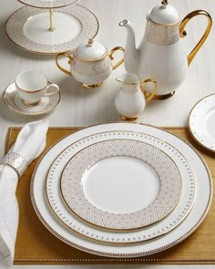 white and gold dinnerware set on a wooden table