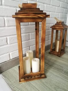 two wooden lanterns sitting on top of a table next to each other with candles in them