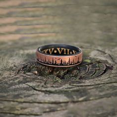 a ring with the word wild written on it sitting on top of a tree stump