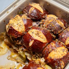 a container filled with meat and potatoes covered in seasoning