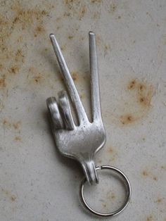 a metal keychain shaped like a peace sign on top of a dirty surface