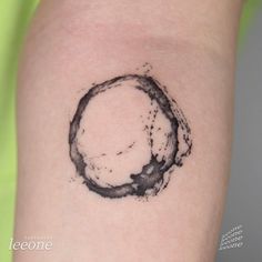 a black ink circle tattoo on the arm