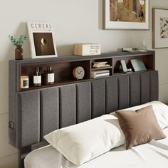 a bed with a book shelf above it and pillows on the headboard next to it