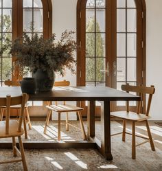 a dining room table with chairs and a potted plant