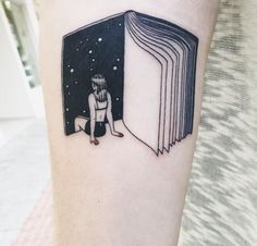 a person with a book tattoo on their arm