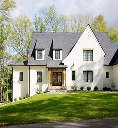 a large white house with black roof and windows