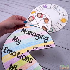 someone is holding their hand over the end of a colorful paper wheel that says managing my emotions