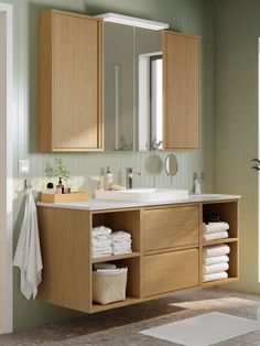 a bathroom with wooden cabinets and white towels