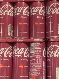 many cans of coca - cola are stacked on top of each other