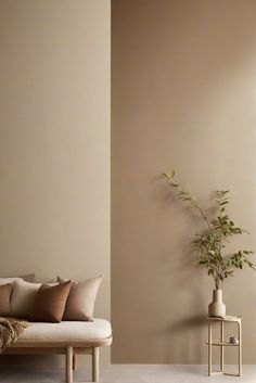 a living room with a couch, table and potted plant on the side wall