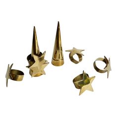 several gold rings and star shaped objects on a white background, including one ring with three pointed stars