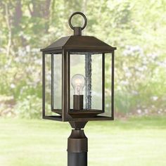 an outdoor post light with a candle on it