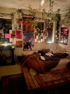 an unmade bed in a room with posters on the wall and lights hanging from the ceiling