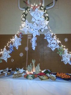 a basketball hoop decorated with paper snowflakes and christmas lights is displayed on a table