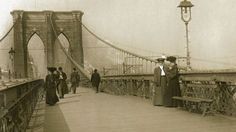 an old photo of people walking across a bridge